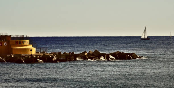 istock Jetty with sailboat in the background 1281213122