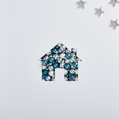 Christmas minimal concept - creative winter layout with shape of house and xmas decoration. Square template, white background. Mockup with house christmas decoration silver on white background.