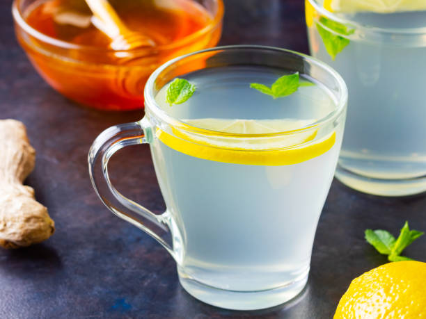 istock Ginger tea with lemon on a dark background. Two cups of ginger tea and ingredients for its preparation 1281213308