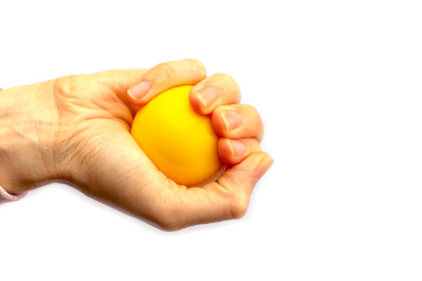 istock Hand holds yellow plastic ball isolated on white background. 1281215640