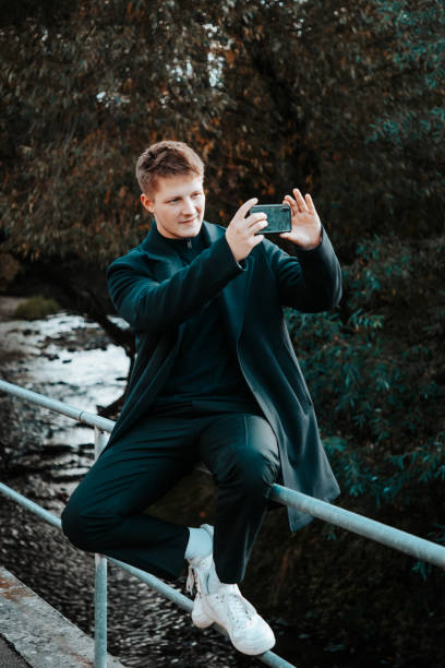 istock Young man snapping pictures with his mobile phone 1281217107