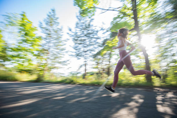 Fit woman jogging in the park on cold autumn morning