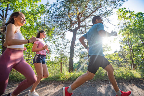 istock Three young people jogging together in nature. 1281218788
