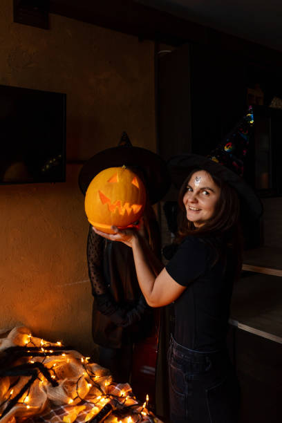 istock Mother and daughter with pumpkin on face 1281220980