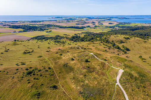 Mols Hills, Denmark - September  17, 2020 - Trehøje seen from above. The three Bronze Age mounds of Trehøje, 127 metres above sea level, offer a panorama view from Aarhus to Ebeltoft, including four inlets: Kalø, Begtrup, Knebel and Ebeltoft. From up here you can see the National Park’s border to the south west, where fertile clay once deposited by the ice means the land is intensely farmed, as opposed to the nutrient-poor sand left by the ice on the hills and on the coastline along Ebeltoft Vig.