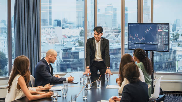 istock Successful presentation. Elegant Asian man explaining growth of sales graph, reporting about good result, motivating workers. Multi ethnic team in board room 1281224243