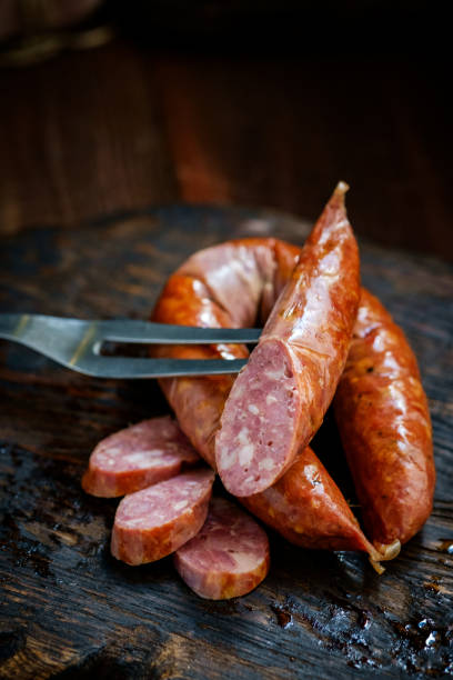 istock Bavarian smoked sausages from pork cut on a wooden Board. Rustic style 1281225382