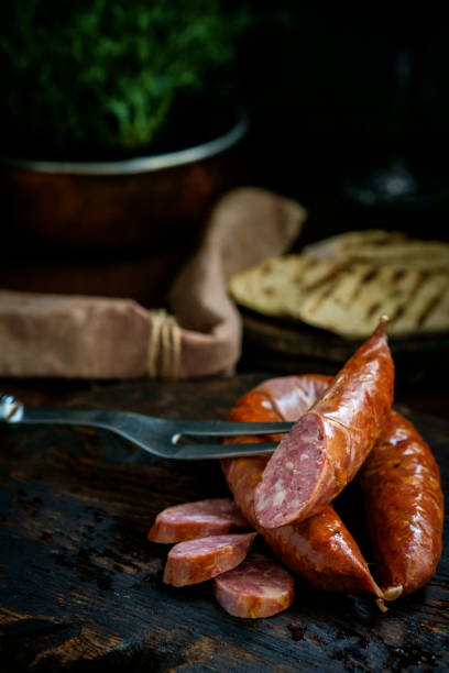 istock Bavarian smoked sausages from pork cut on a wooden Board. Rustic style 1281225402