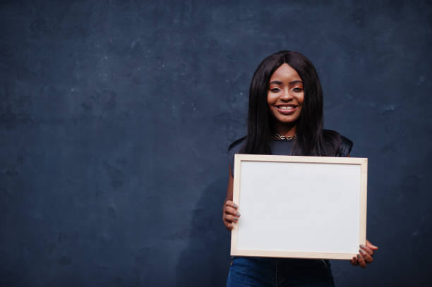 istock Fashionable african woman hold empty white board. 1281227247