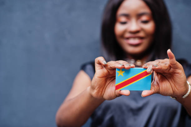 африканская женщина держит в руках небольшой флаг др конго. - congolese flag стоковые фото и изображения