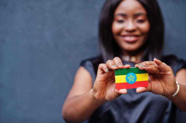 african woman hold small ethiopia flag in hands. - etiopia i imagens e fotografias de stock