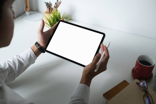 istock Cropped shot of male designer using empty screen digital tablet with stylus pen on white office desk. 1281227609