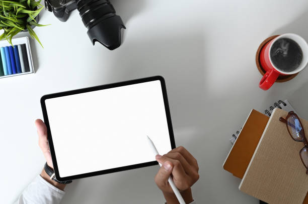 istock Top view of young professional designer drawing his project with blank screen tablet in comfortable workspace. 1281227628