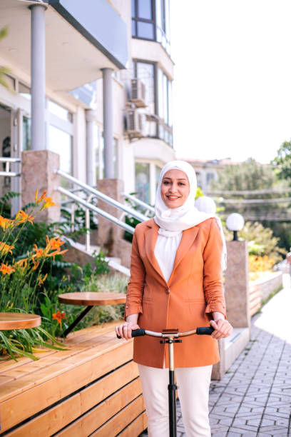 istock Attractive muslim woman riding a kick scooter. 1281228886