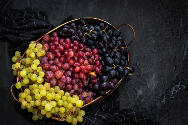 istock White, red and black fresh autumn grapes on dark background, top view 1281229460