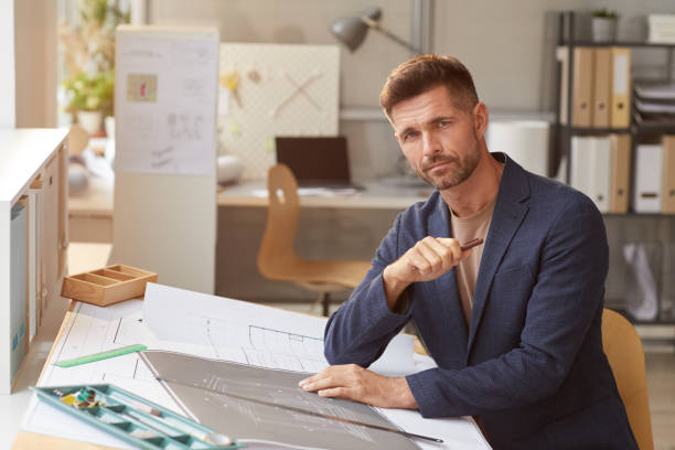 istock Mature Man Drawing Bluerints in Office 1281231934