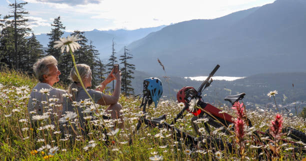istock Couple with mountain e-bikes relax amongst wildflowers in alpine meadow 1281232521