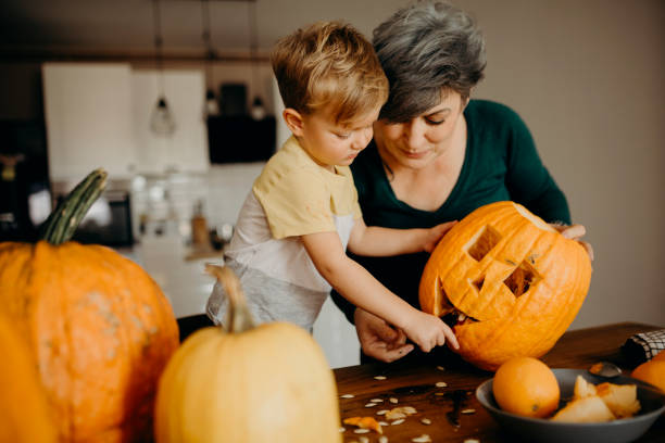 istock Grandma helps her grandson cut pumpkin 1281234057