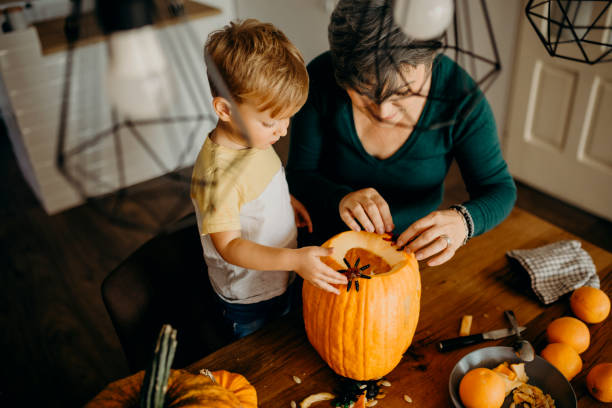 istock Grandma helps her grandson cut pumpkin 1281234200