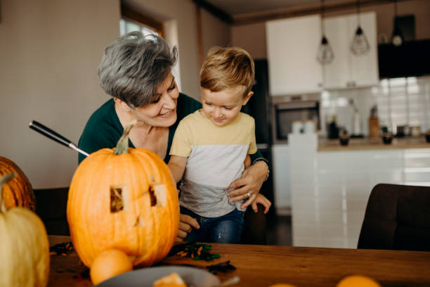 istock Grandma helps her grandson cut pumpkin 1281235055