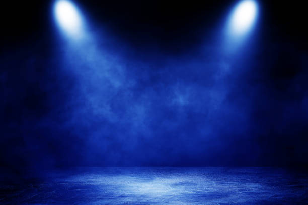 istock Studio dark room concrete floor grunge texture background with blue lighting effect and smoke in background. 1281235257