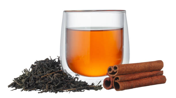 istock Glass cup of tea and cinnamon sticks isolated on white 1281237005