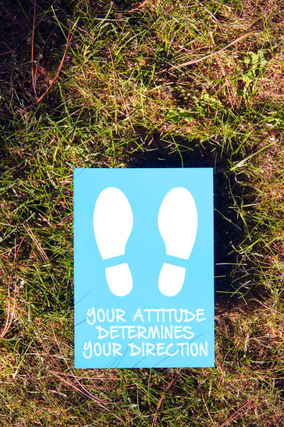 istock Your attitude determines your direction message written on paper with footprint on grass background. Inspirational motivational quote. 1281237318