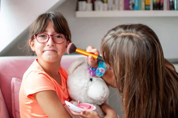 istock Cute girl fixing make up to her sister 1281246232
