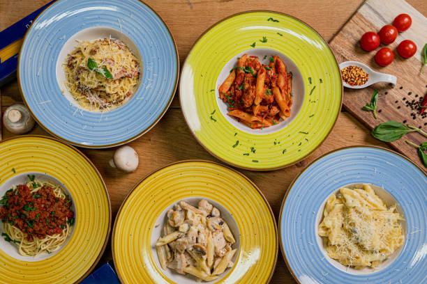 istock Several plates of pasta & spaghetii with different kinds of sauce over wooden background, top view. Concepts of Italian food. 1281246292