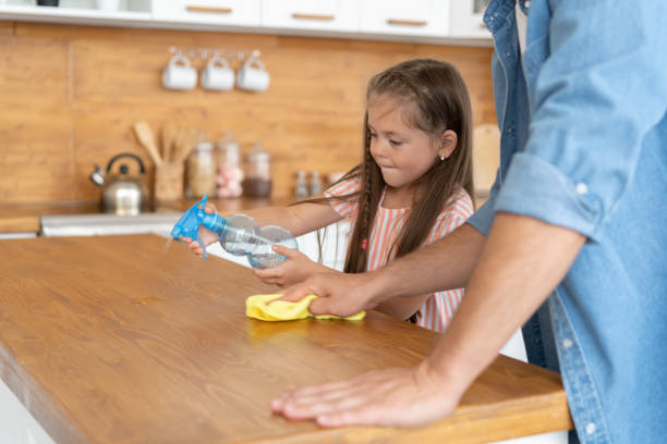 istock Cleaning time. Grey-haired Mature handsome man cleaning kitchen with daughter at the weekend. 1281246648