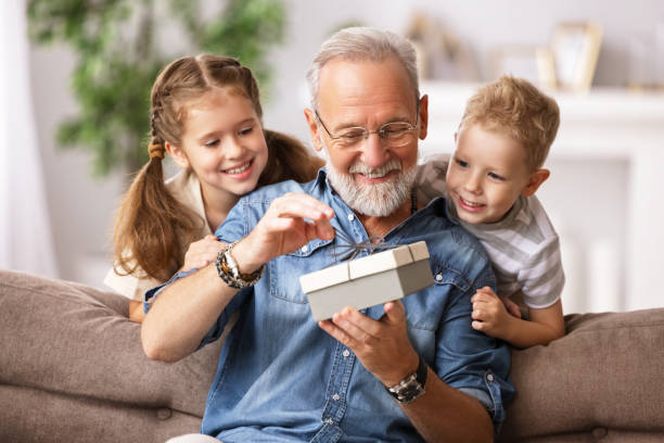 regalo di apertura nonno e nipoti - grandfather adult affectionate little boys foto e immagini stock