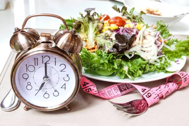 istock Alarm clock  with salad plate which a Concept of intermittent fasting, breakfast diet and weight loss lifestyle 1281248722