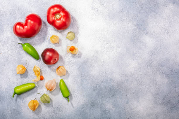 istock Tomatoes, physalis, jalapeno peppers atop grey backdrop w/ copy space, top  view. Solanaceous crops 1281249814
