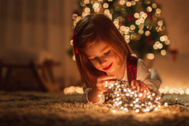 istock Little girl playing with Christmas lights 1281252624