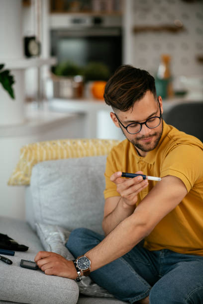 istock Young man giving himself an insulin shot at home. 1281256537