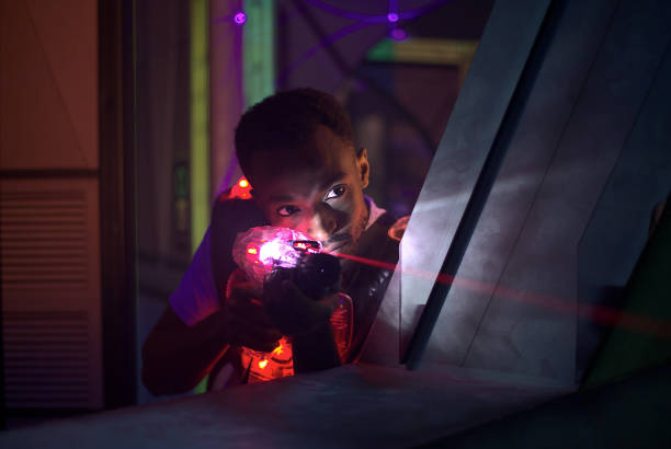 laser gun game shooting player enjoying leisure activity laser gun player shooting in futuristic labyrinth playing tag stock pictures, royalty-free photos & images