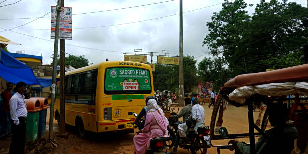 indian street people lifestyle DISTRICT KATNI, INDIA - DECEMBER 12, 2019: sacred heart senior secondary school student transportation bus going between traffic on road. village maharashtra stock pictures, royalty-free photos & images