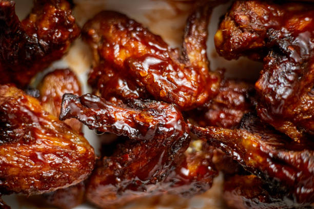 istock Close up on Chicken wings in thick barbecue sauce. Served on white cast iron dish 1281259971