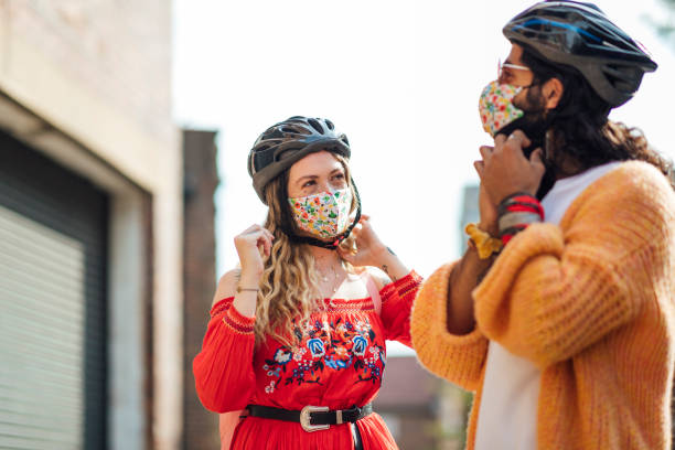 istock Couple Wearing Reusable Protective Face Masks and Cycling Helmets 1281260699