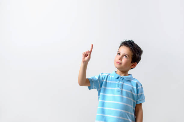 istock A boy in a blue T-shirt with a brooding face raised his finger up. 1281261478