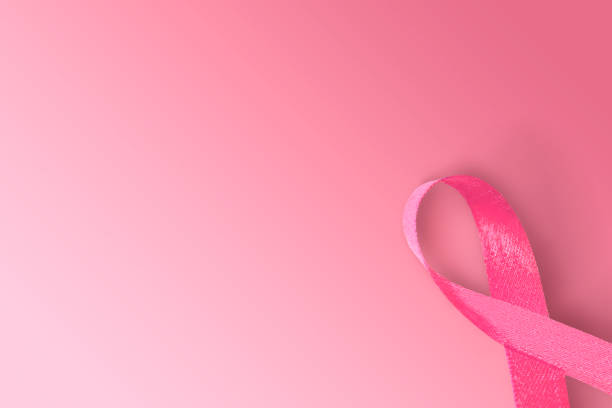 istock Pink awareness ribbon on pink background 1281263697