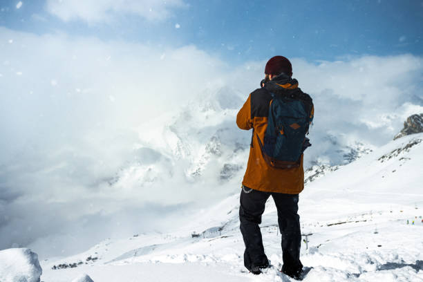 istock Photographer shooting mountains at snowy weather 1281264565