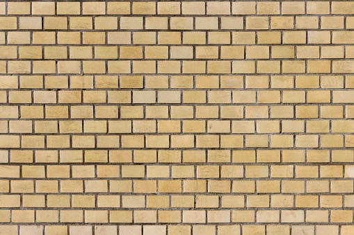 Surface of a yellow brick wall.