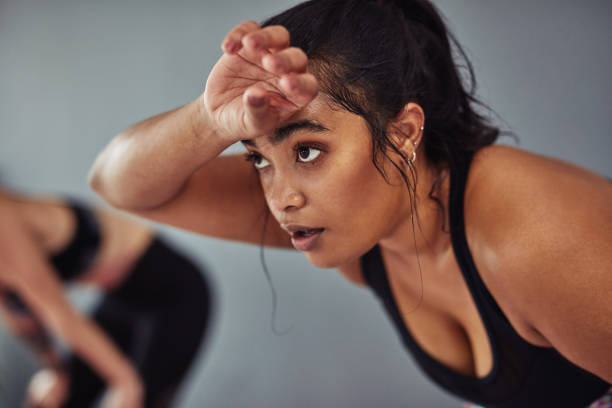 You're tougher than your toughest workout Shot of a young woman taking a break from her workout at the gym sweat stock pictures, royalty-free photos & images