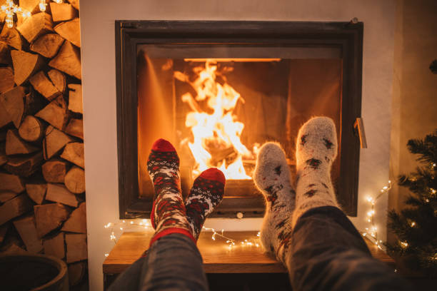 Winter day by fireplace Lazy winter day in front of fire in fireplace. Human legs in Christmas socks in front of fireplace. cozy stock pictures, royalty-free photos & images