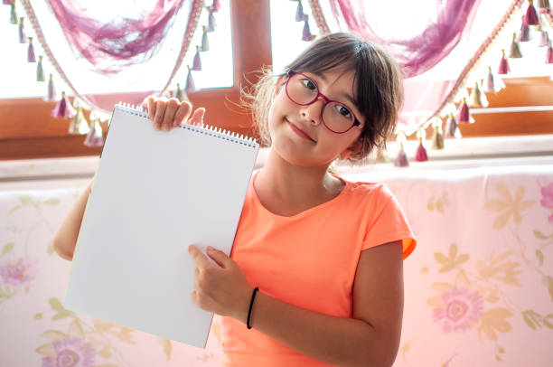 istock Child girl holding white sheet blank 1281276556