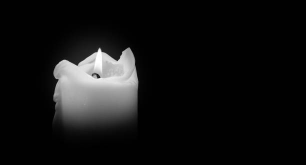 ljus brinner på natten. white candles burning in the dark med fokus på ett ljus i förgrunden - grief bildbanksfoton och bilder
