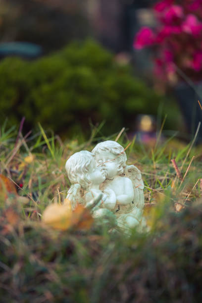 istock Remembrance concept: White angel on a grave, flowers 1281278033