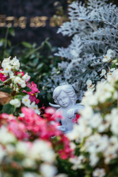 istock Remembrance concept: White angel on a grave, flowers 1281278208