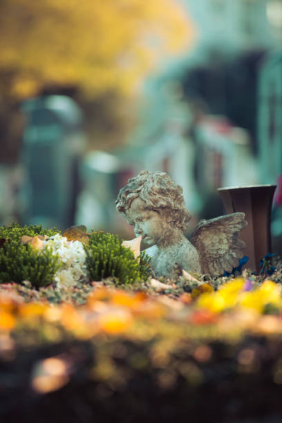 istock Remembrance concept: White angel on a grave, flowers 1281278393